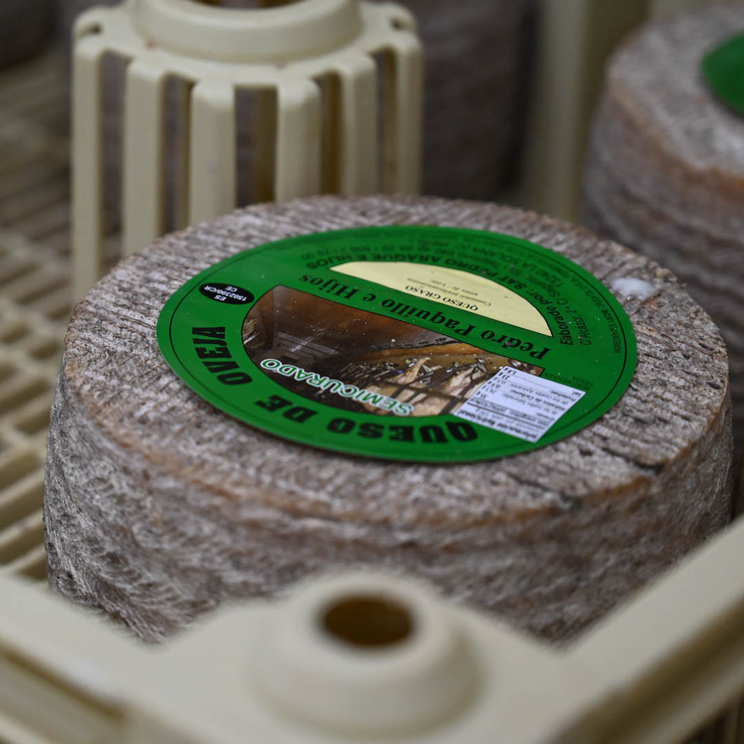 Queso con la etiqueta verde del semicurado madurando en su caja